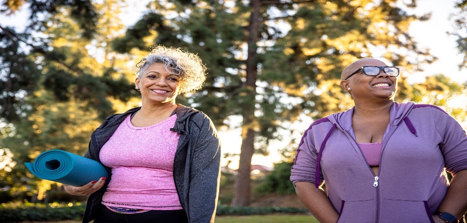 Elderly women outdoors carrying a yoga mat